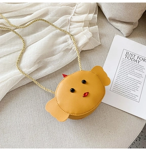 Detail of yellow chick mini crossbody bag with golden braided strap and leather texture