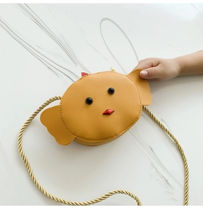 Detail of a mini yellow cartoon chicken purse made of PU leather with golden strap