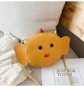 Detail view of a yellow chick-shaped mini shoulder bag with a woven strap for kids