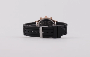 Detail view of rose gold watch case with black silicone strap and silver buckle