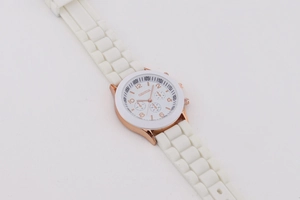 Detail of white silicone strap and rose gold Geneva quartz watch dial with sub-dials