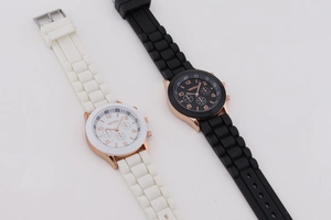 Detail view of black and white Geneva silicone watches with rose gold triple-dial design