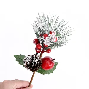 Artificial Christmas pine needles with pinecone, red berries, and snow effect on white