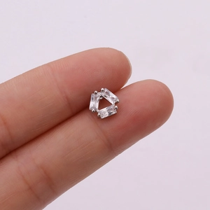 Close-up of rose gold cartilage earring with three clear zircons held by hand