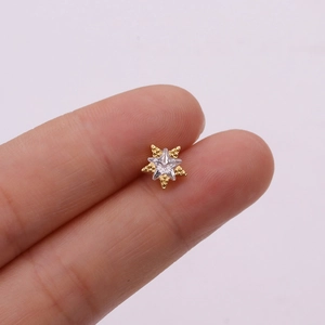 Detailed macro view of a rose gold star stud earring with a central clear zircon inlay