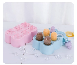 Detail view of 6-hole silicone popsicle molds in pink and blue with cartoon animal shapes