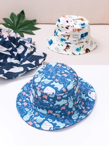 Dettaglio di cappelli alla pescatora per bambini in cotone con stampe di animali e bottoni