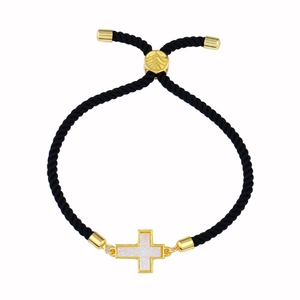 Dettaglio di bracciale intrecciato nero regolabile con ciondolo a croce dorata e chiusura