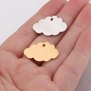 Golden and silver mirror polished stainless steel cloud pendants held for size scale