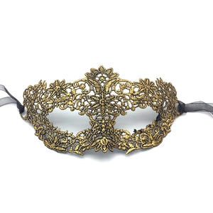 Detail of gold lace masquerade mask showing intricate embroidery and black satin ribbons