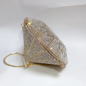 Close-up of diamond-shaped clutch bag with silver rhinestones and gold metal frames
