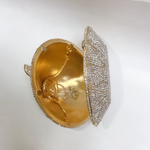 Macro detail of diamond-shaped clutch bag showing gold interior and crystal exterior