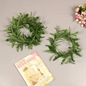 Detailed close-up of dark green olive and eucalyptus leaves on a circular faux wreath