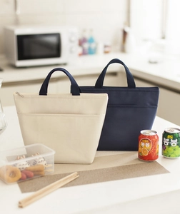 Thick insulated Oxford fabric lunch bags in beige and navy blue on a kitchen counter