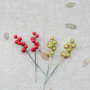 Close-up of artificial red and gold glitter berry stems for Christmas tree decoration
