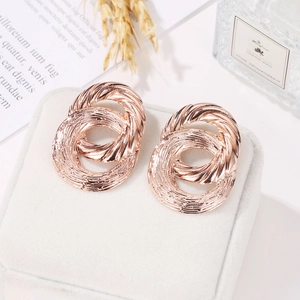 Rose gold double circle twist earrings displayed on elegant velvet jewelry box
