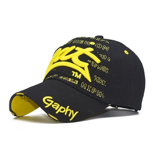Close-up of 3D yellow embroidery and distressed details on a black cotton baseball cap