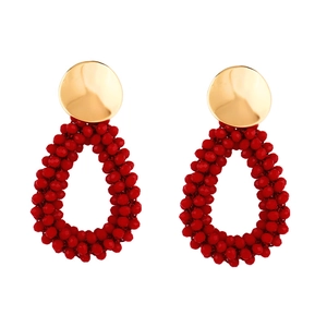 Vue détaillée de boucles d'oreilles gouttes en perles rouges avec clous dorés ronds