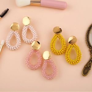 Détail de boucles d'oreilles en perles de rocaille en forme de goutte, blanc, rose et jaune
