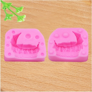 Close-up of two pink food-grade silicone molds for cake decorating on wood background