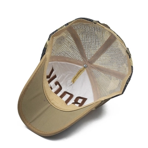 Detail view of the breathable camouflage mesh and internal embroidery of the baseball cap
