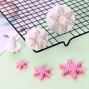 Macro detail of three snowflake spring plungers and pink fondant shapes for baking