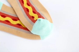 Close-up of a cotton sock heel featuring a colorful hot dog pattern with mint green trim