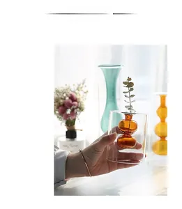 Dettaglio del moderno vaso nordico in vetro colorato a doppio strato tenuto in mano