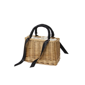 Handmade straw basket bag with black ribbon handle and drawstring liner in a 45-degree angle