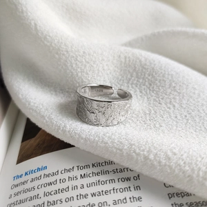 Macro detail of S925 sterling silver hallmark on an irregular textured open ring