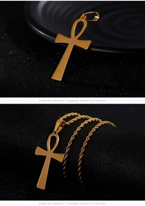 Detailed view of golden Ankh cross pendant on a twist chain against a dark background