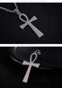 Detailed view of silver Ankh cross pendant with twisted chain on black textured surface