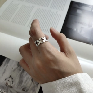 Close-up of minimalist S925 sterling silver woven ring worn on the index finger