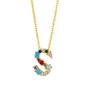 Macro detail of gold S letter pendant necklace with colorful cubic zirconia stones