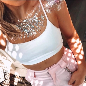 Macro detail of iridescent AB resin crystals and glitter on model's collarbone