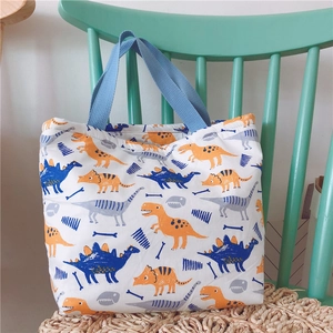 Detail der Canvas-Lunchtasche mit bunten Dinosaurier-Prints und blauen Tragegriffen