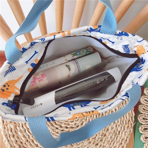 Draufsicht der weißen Canvas-Lunchtasche mit Dino-Print und Reißverschluss-Innenraum