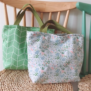 Details von geblümten und geometrischen Baumwolltaschen auf einem Holzstuhl