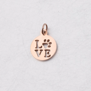 Dettaglio macro del ciondolo LOVE in acciaio inossidabile oro rosa con intaglio di zampa