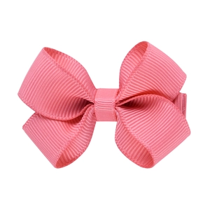 Détail de la texture ruban rose sur une barrette à cheveux classique pour enfant