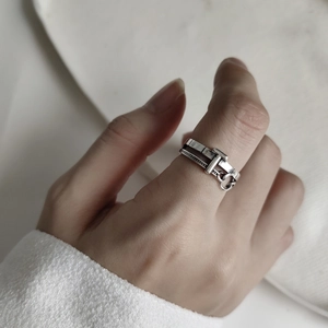 Macro detail of retro S925 silver T-shaped ring with industrial belt buckle chain texture