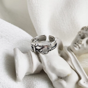 Detailed macro view of S925 sterling silver buckle ring with retro chain on a white statue