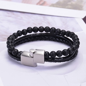 Macro detail of men's leather bracelet with black lava stone beads and silver magnetic clasp