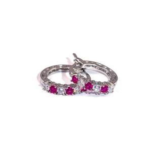 Macro view of silver hoop earrings with alternating red and white cubic zirconia stones
