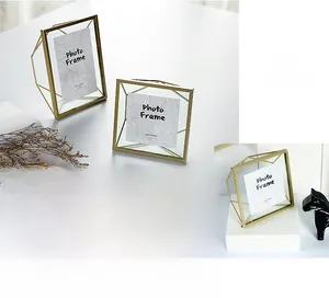 Close-up of geometric gold metal frame with 4x6 glass panels on a minimalist desk