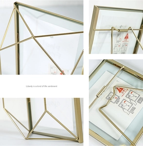Macro detail of geometric gold metal photo frame showing glass panel and iron support stand