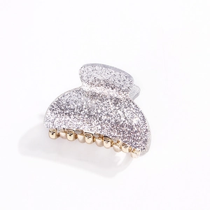 Close-up of silver glitter hair claw clip with sturdy gold metal teeth for secure grip
