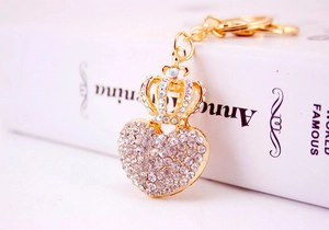 Macro shot of gold heart-shaped keychain with crown and sparkling clear rhinestones