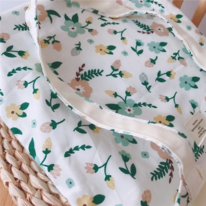 Close-up of floral canvas tote bag featuring small flowers and woven label detail
