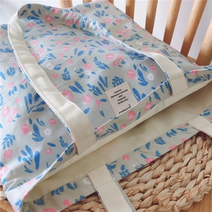 Detail of floral cotton tote bag with sturdy straps on a wooden chair for a natural look